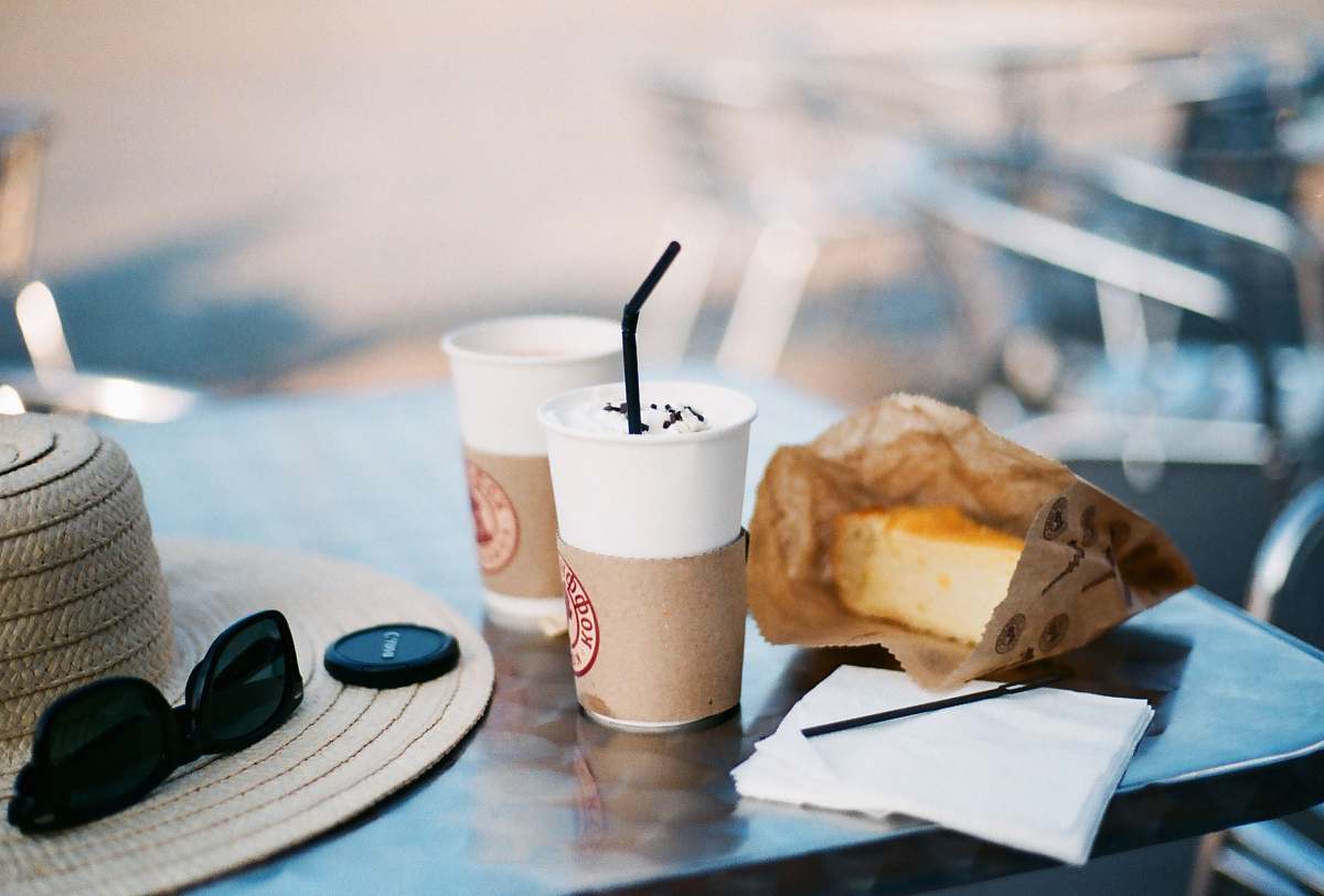 coffee shop selective focus photography of bread and sip bottle on table cake